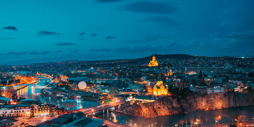 High angle view of illuminated buildings against sky at night