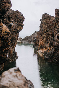 Rock formations by sea against sky