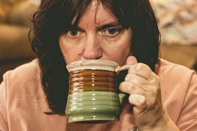Close-up of woman having drink in cup
