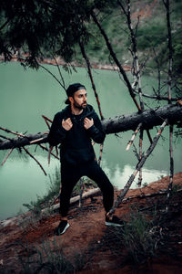 Full length of man standing by tree in forest