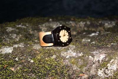 Close-up of wristwatch on rock