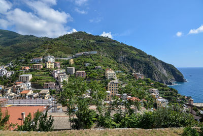 Scenic view of townscape by sea against sky