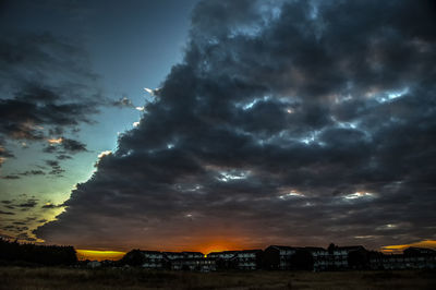 Scenic view of dramatic sky over city during sunset