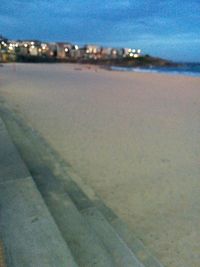 Close-up of illuminated beach against blue sky