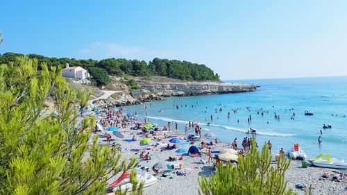 People on beach against blue sky