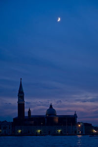 Illuminated building against sky at dusk