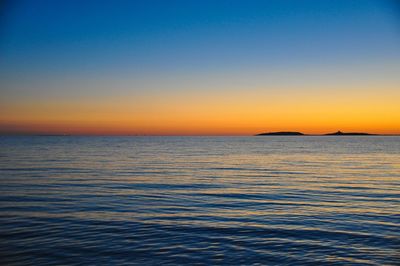 Scenic view of sea against clear sky during sunset
