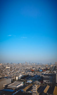 High angle view of buildings against blue sky