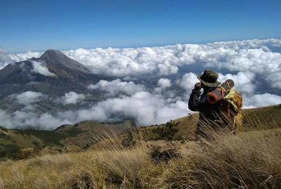 Man standing on mountain road against sky