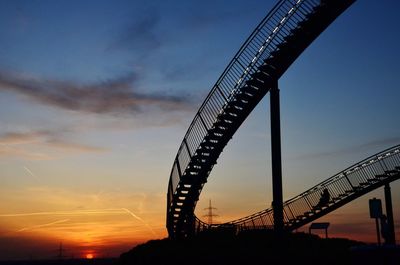 Low angle view of silhouette bridge against sky during sunset