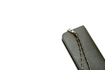 Close-up of black clutch bag over white background