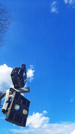 Low angle view of camera against blue sky