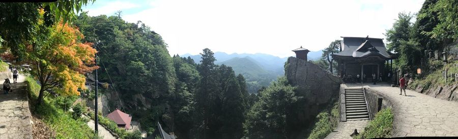 Panoramic view of trees and buildings against sky