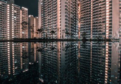 Reflection of illuminated buildings on pond at night