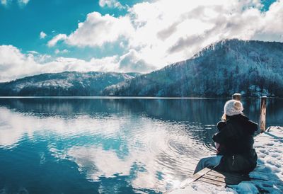 Rear view of woman in lake against mountains