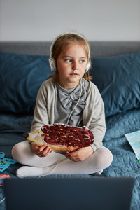 Little girl preschooler learning online showing her works drawings done at home