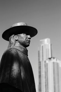 Low angle view of statue and building against clear sky