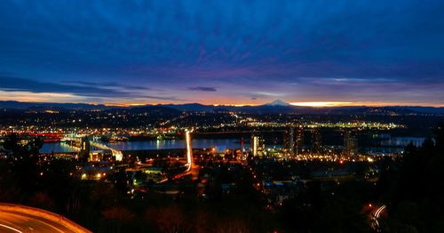 Illuminated cityscape against sky at night