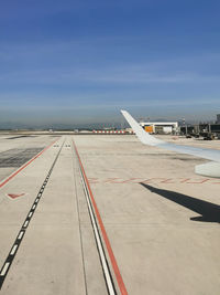 Airplane on airport runway against sky