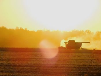 Scenic view of field against clear sky during sunset