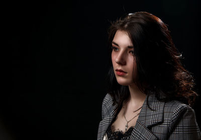 Portrait of a beautiful young woman over black background