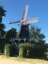 Low angle view of traditional windmill against clear blue sky