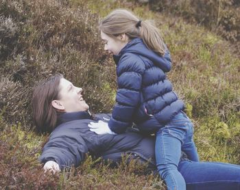 Full length of girl relaxing on grassy field