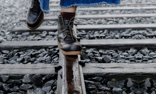 Low section of person standing on railroad track