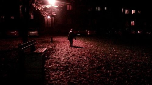 Man on illuminated street at night