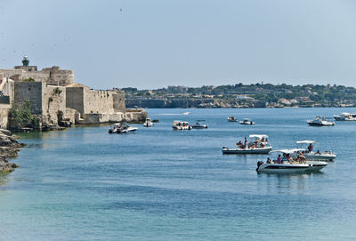 Boats in sea against sky