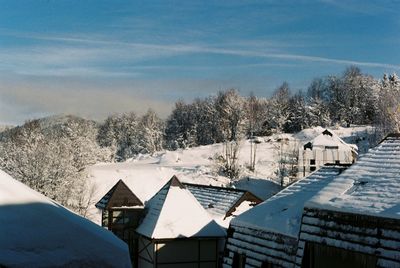 Houses on snowcapped mountain against sky