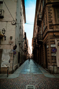 Cobblestone street amidst buildings against sky