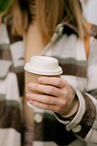 Midsection of woman holding coffee cup