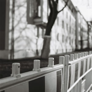 Close-up of railing by fence in city
