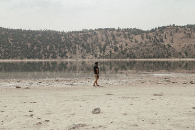 Full length of man standing on beach against sky