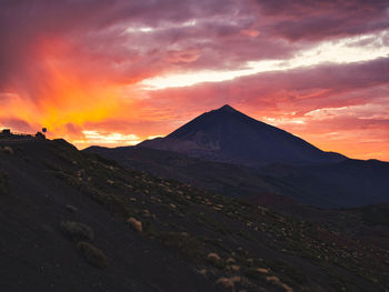 Scenic view of mountain against cloudy sky during sunset