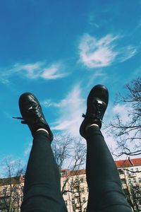 Low angle view of person standing against blue sky