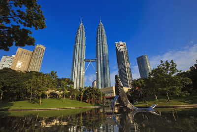 Malaysia, kuala lumpur, pond and whale sculpture in klcc park with petronas towers in background