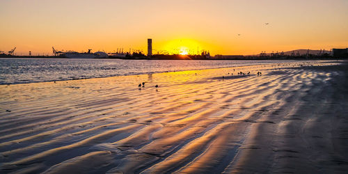 Scenic view of beach against sky during sunset