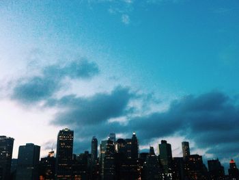 Modern cityscape against cloudy sky