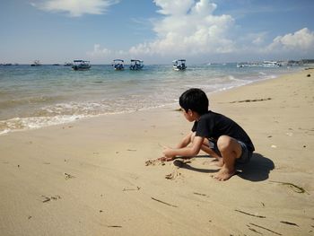 Boy playing with sand at beach