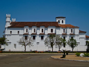 Building by road against clear blue sky