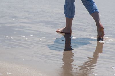 Low section of woman standing on beach