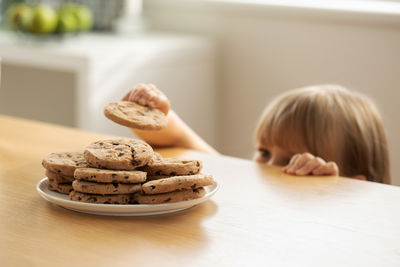 High angle view of girl with cookies on table