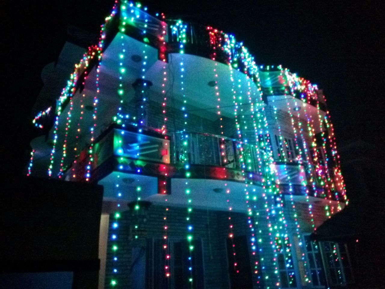 LOW ANGLE VIEW OF ILLUMINATED LIGHTS AGAINST SKY AT NIGHT