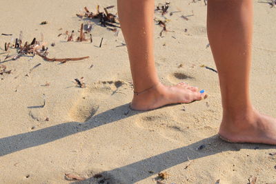 Low section of child on sand at beach