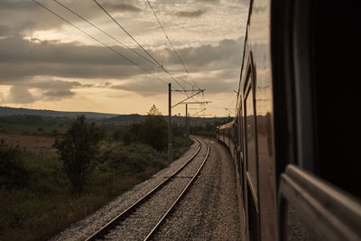 Railroad tracks against sky during sunset