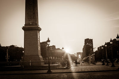 Statue in city against sky