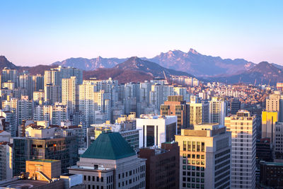 Aerial view of buildings in city against clear sky