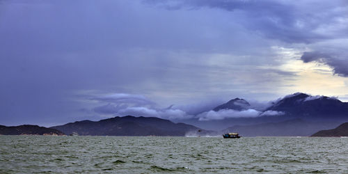 Scenic view of sea and mountains against sky